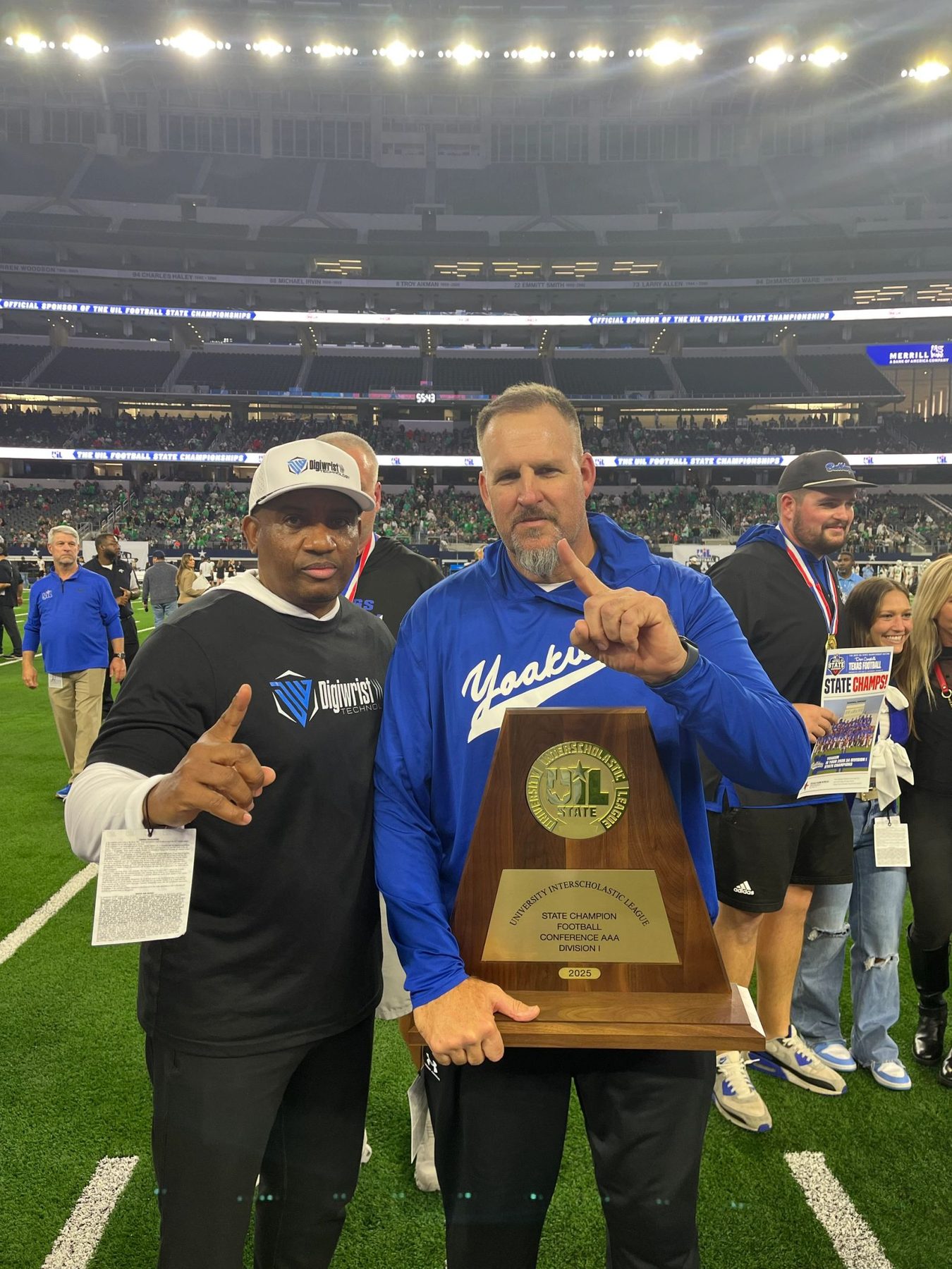 Yoakum coaches with the Class 3A-DI state championship trophy on the field
