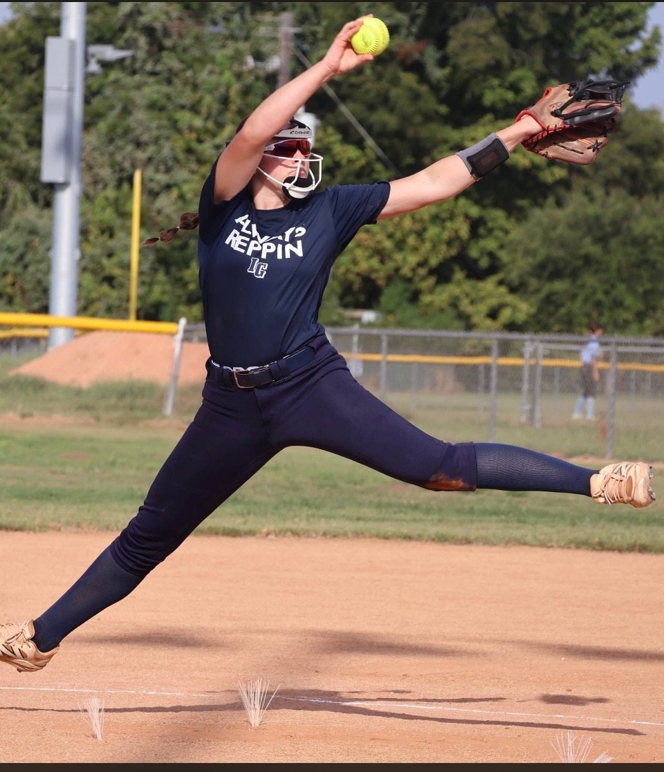 Softball pitcher mid-delivery wearing a DigiWrist receiver